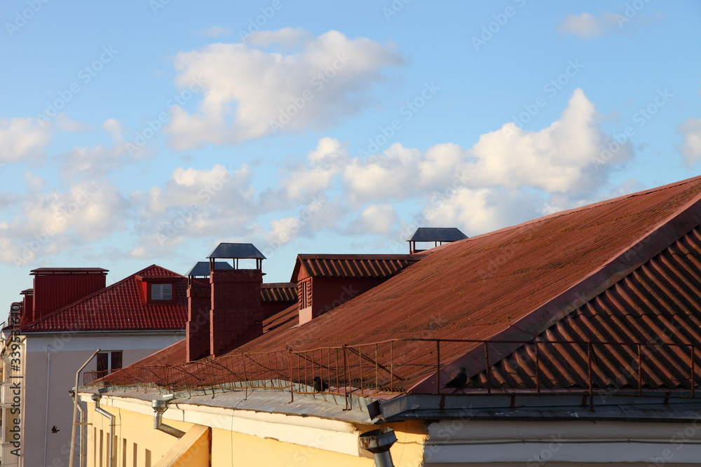 Scenery red tiled roofs, houses  against a blue sky with clouds, Europe old city landscape at Sunny spring day