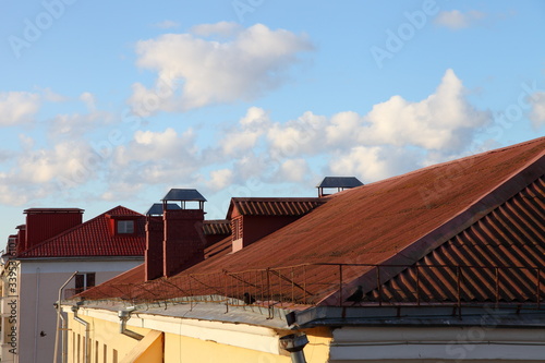 Scenery red tiled roofs, houses against a blue sky with clouds, Europe old city landscape at Sunny spring day