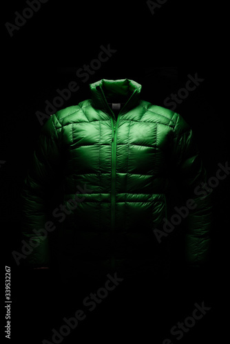 Fototapeta Naklejka Na Ścianę i Meble -  Green down jacket in static position with ghost effect and black background