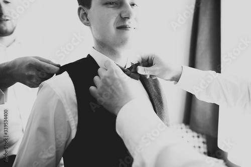 Grooms morning preparation. Handsome man getting dressed and preparing for the wedding photo