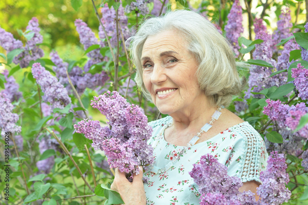 Close up portrait of happy senior beautiful woman with lilacs Close up portrait of happy senior beautiful woman with lilacs