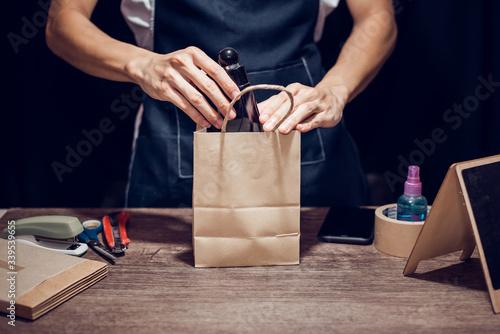 Working at home concept, Packing product in paper bag, Close-up.