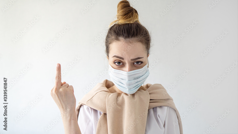 Young beautiful european girl in mask on isolated white background Showing  middle finger doing fuck you bad expression, provocation and rude attitude.  Coronavirus outbreak or Covid-19 Stock-Foto | Adobe Stock