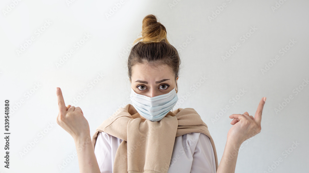 Young beautiful european girl in mask on isolated white background Showing middle finger . Coronavirus outbreak or Covid-19, Concept of Covid-19 quarantine Young beautiful european girl in mask on isolated white background Showing middle finger . Coronavirus outbreak or Covid-19, Concept of Covid-19 quarantine