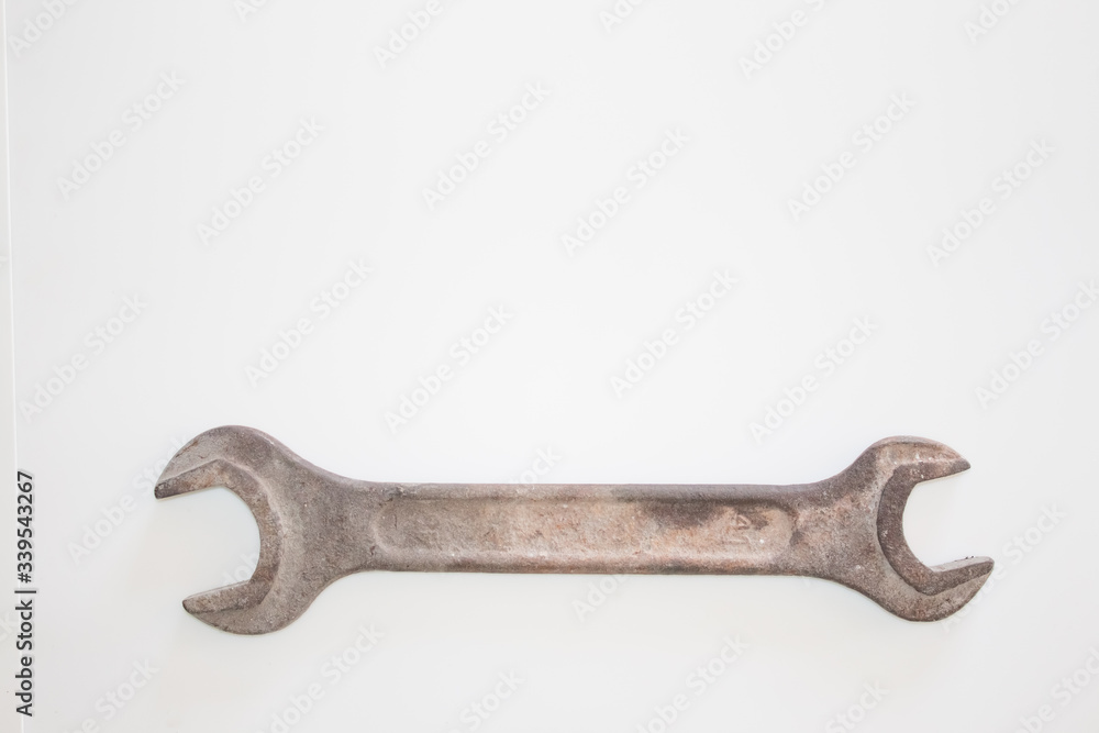 Old rusty wrench on a white and metal background. several wrenches of different sizes. Card with copy space for text Old rusty wrench on a white and metal background. several wrenches of different sizes. Card with copy space for text
