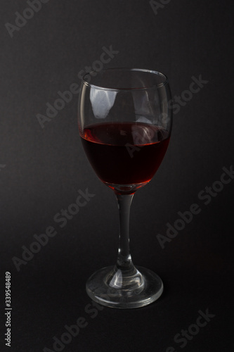 hermosas copas de vino transparentes con vino tinto sobre un fondo negro
