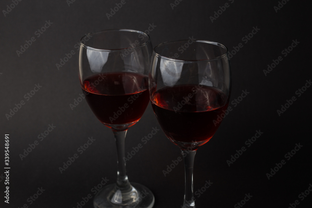 hermosas copas de vino transparentes con vino tinto sobre un fondo negro hermosas copas de vino transparentes con vino tinto sobre un fondo negro