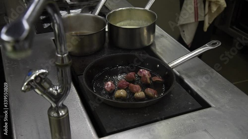 Cuisson de rognons dans une poêle dans une cuisine professionnelle de restaurant photo