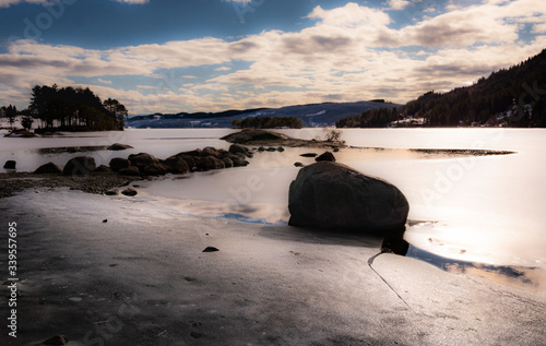 Landscape with a frozen lake with rocks 