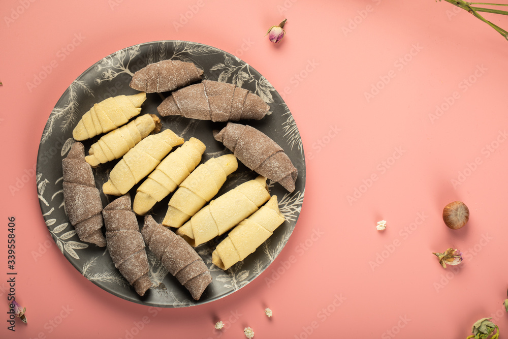 Caucasian sweets mutaki made with vanilla and cocoa dough in a black platter isolated on pink Caucasian sweets mutaki made with vanilla and cocoa dough in a black platter isolated on pink