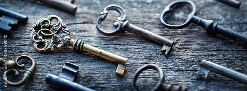 Old door keys lying on the table. Choose the right key. Concept on the topic of security, choice, search, etc. Retro style.