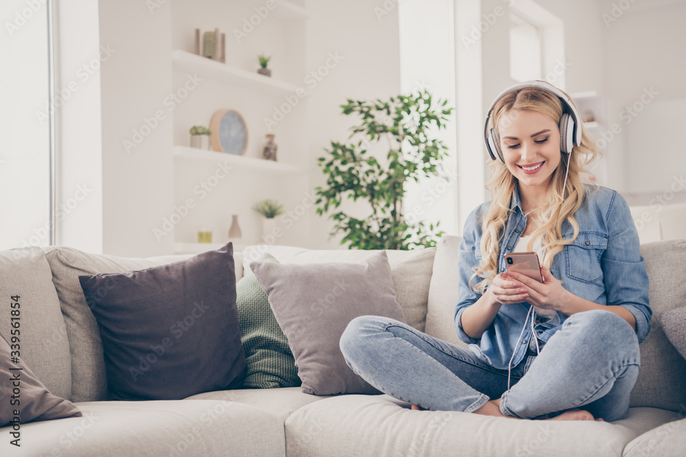 Photo of charming blond lady sit comfy couch legs crossed staying home listen cool earphones youth music choose song telephone browsing quarantine time living room indoors Photo of charming blond lady sit comfy couch legs crossed staying home listen cool earphones youth music choose song telephone browsing quarantine time living room indoors