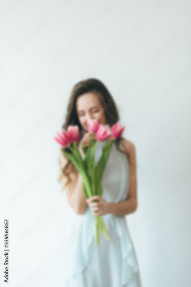 Girl with pink tulips on the background. Woman and tulips