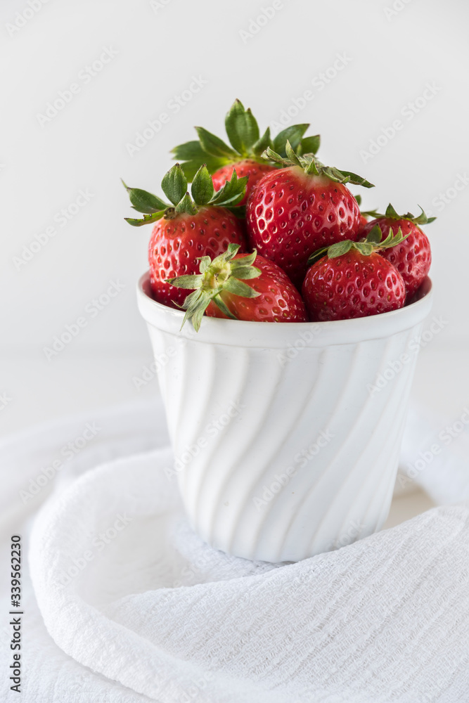 Strawberries in a white porcelain bowl on white background Strawberries in a white porcelain bowl on white background