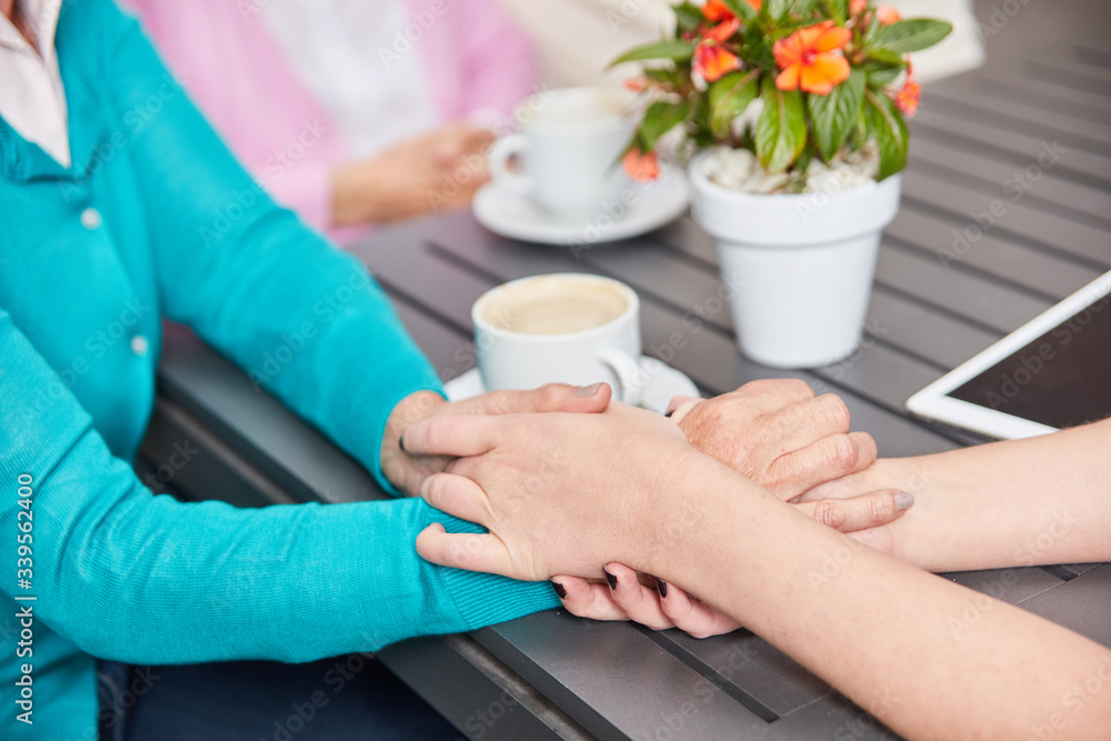 Pflegekraft hält Hand einer Seniorin zum Trost Pflegekraft hält Hand einer Seniorin zum Trost