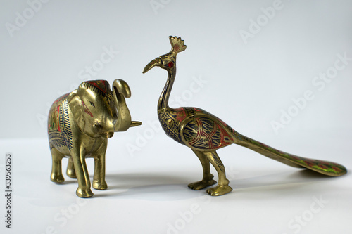 Small Golden Statues of Elephant and Peacock on White Background