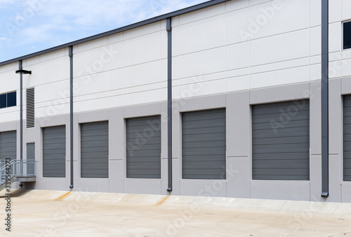 Fototapeta Naklejka Na Ścianę i Meble -  Empty warehouse loading dock white walls gray metal sliding doors