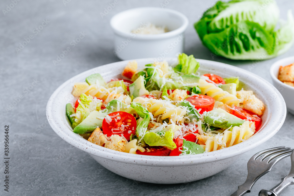 Fusilli pasta salad with avocado, tomatoes, fresh green lettuce, parmesan cheese and croutons Fusilli pasta salad with avocado, tomatoes, fresh green lettuce, parmesan cheese and croutons