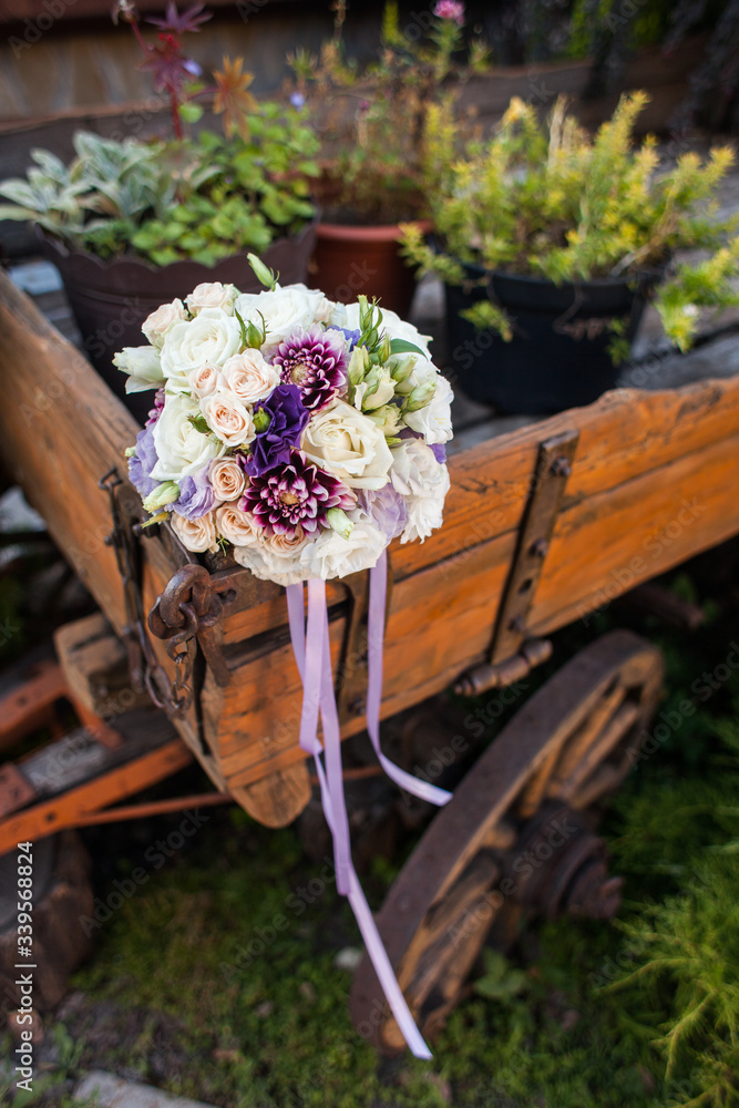 Wedding bouquet in purple tones on a wooden cart