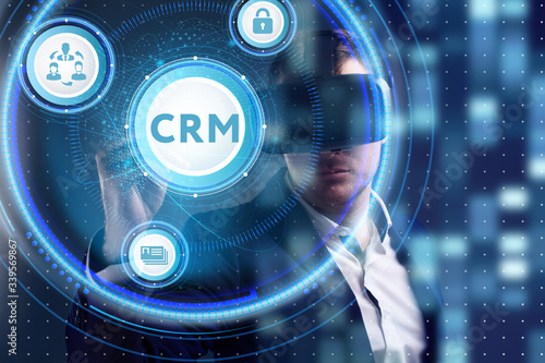 Business, Technology, Internet and network concept. Young businessman working on a virtual screen of the future and sees the inscription: CRM