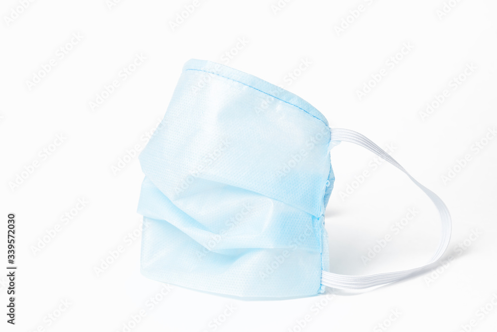 Medical disposable professional mask as a means of personal protection against the virus and bacteria during the spread of the coronavirus influenza pandemic. Respirator in blue on white background. Medical disposable professional mask as a means of personal protection against the virus and bacteria during the spread of the coronavirus influenza pandemic. Respirator in blue on white background.
