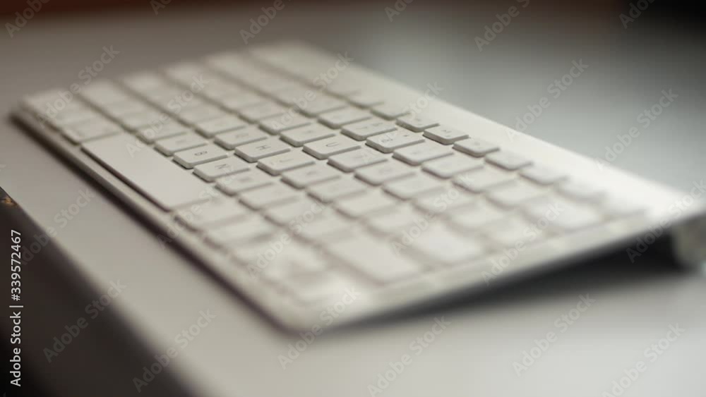 A male Asian hand is typing on a keyboard. A male Asian hand is typing on a keyboard.