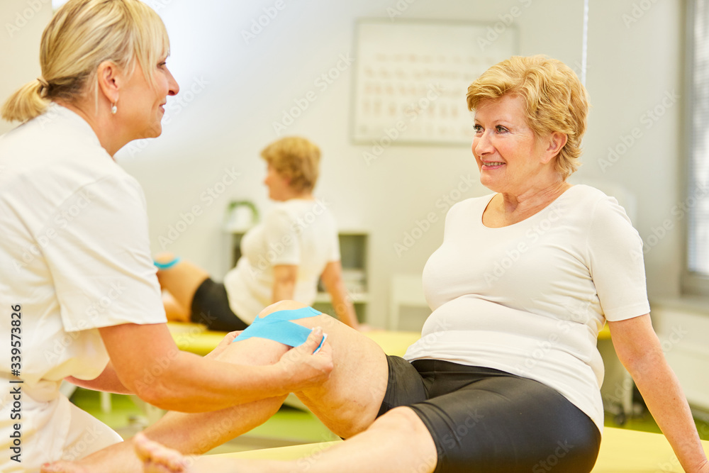 Fototapeta premium Alternative practitioner attaches Kinesio Tape to the patient