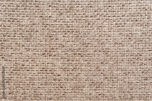 Pattern of a decorative beige sackcloth or burlap cloth. Close up view. Materials concept.