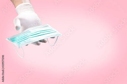 Hands in white gloves showing medical face mask on background. Preventive measures to protect against virus infection.