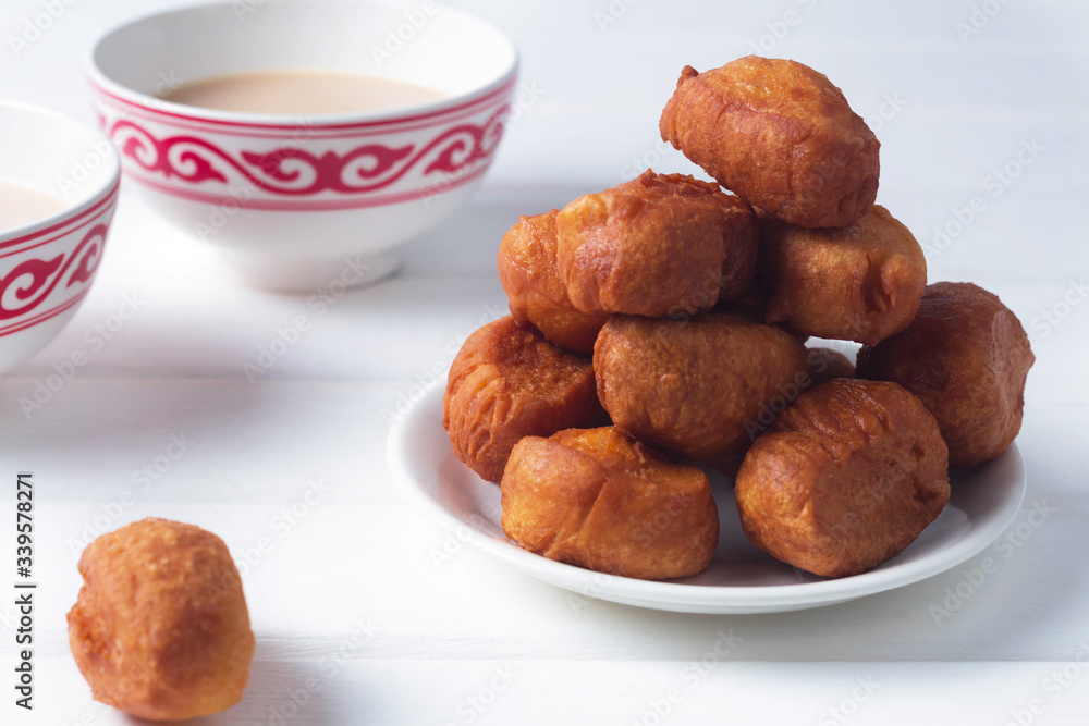 Baursaki in a plate and tea in kesa with a national pattern, Bashkir dishes, Uzbek dishes, oriental cuisine Baursaki in a plate and tea in kesa with a national pattern, Bashkir dishes, Uzbek dishes, oriental cuisine