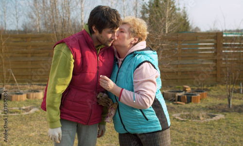 Mom and son in the garden in spring. Mother hugging and kissing her son. Mothers day, family relations concept