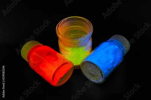 Photoluminescence chemical materials, called fluorescent. Powder glows in the dark under UV light radiation of different colors. photo