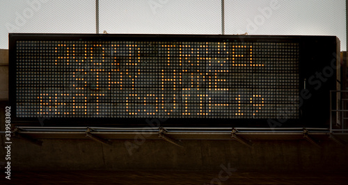 Freeway overpass sign stating Avoid Travel ,Stay Home,Beat COVID-19
