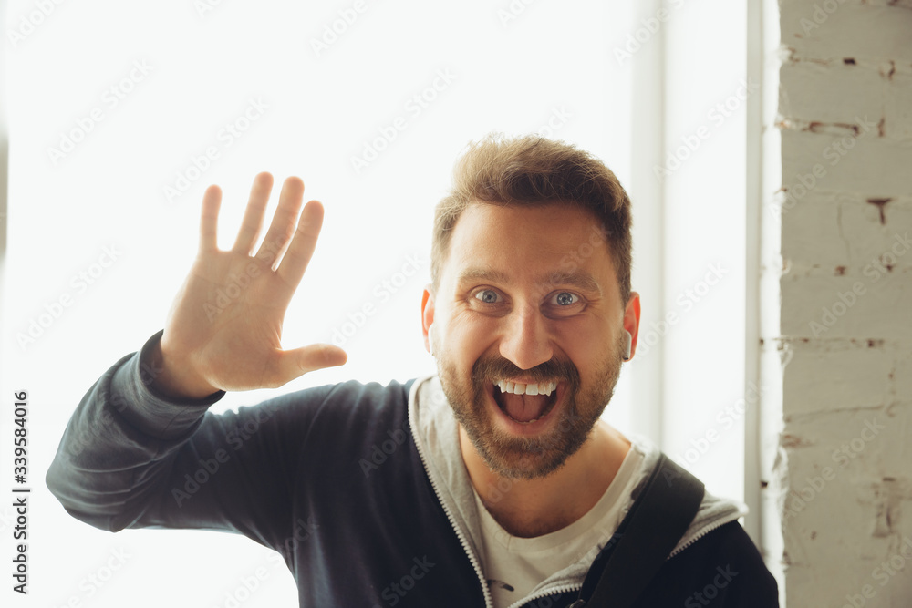Caucasian musician greeting audience during online concert at home isolated and quarantined. Looks cheerful and smiling, thumb up. Concept of art, support, music, hobby, education. Caucasian musician greeting audience during online concert at home isolated and quarantined. Looks cheerful and smiling, thumb up. Concept of art, support, music, hobby, education.