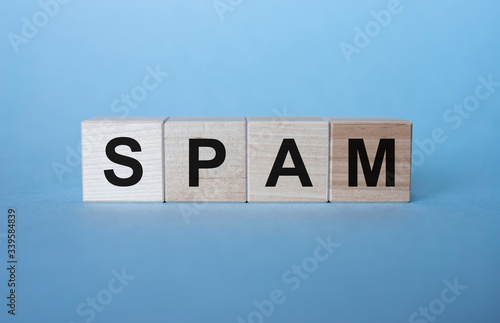 Word SPAM on wooden cubes on light blue background photo