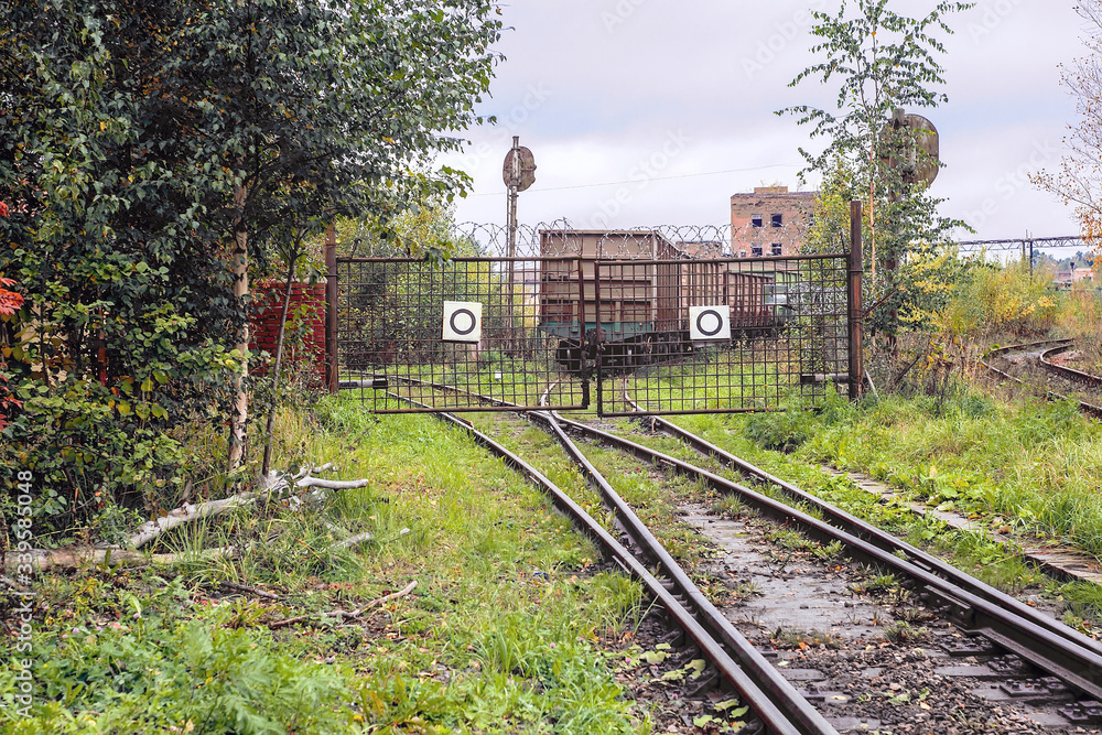 The the railway track abuts against closed lattice metal gates, behind which the rails diverge in two different directions