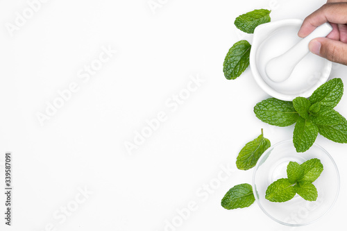 Obraz na płótnie Man hand with mortar grind and herbs isolated on white background