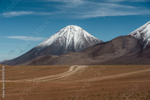 road leading to snow capped volcano in Atacama Desert Chile