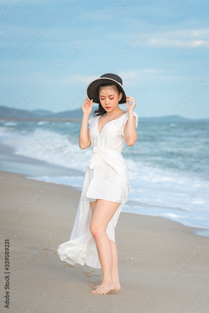 Beautiful women in white dress happily strolling at the beach, beautiful women dressed in white bride Beautiful women in white dress happily strolling at the beach, beautiful women dressed in white bride