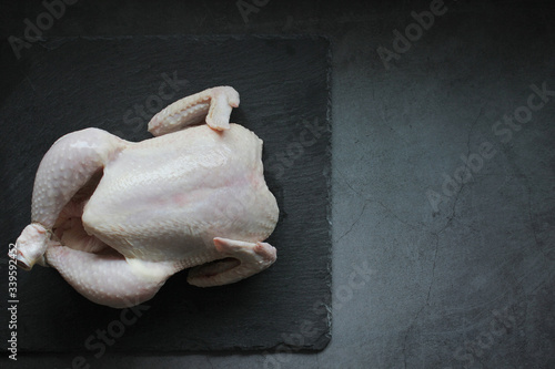 Fototapeta Naklejka Na Ścianę i Meble -  Fresh chicken without spices on dark background, selective focus. Healthy food, diet or cooking concept. Top view, copy space.