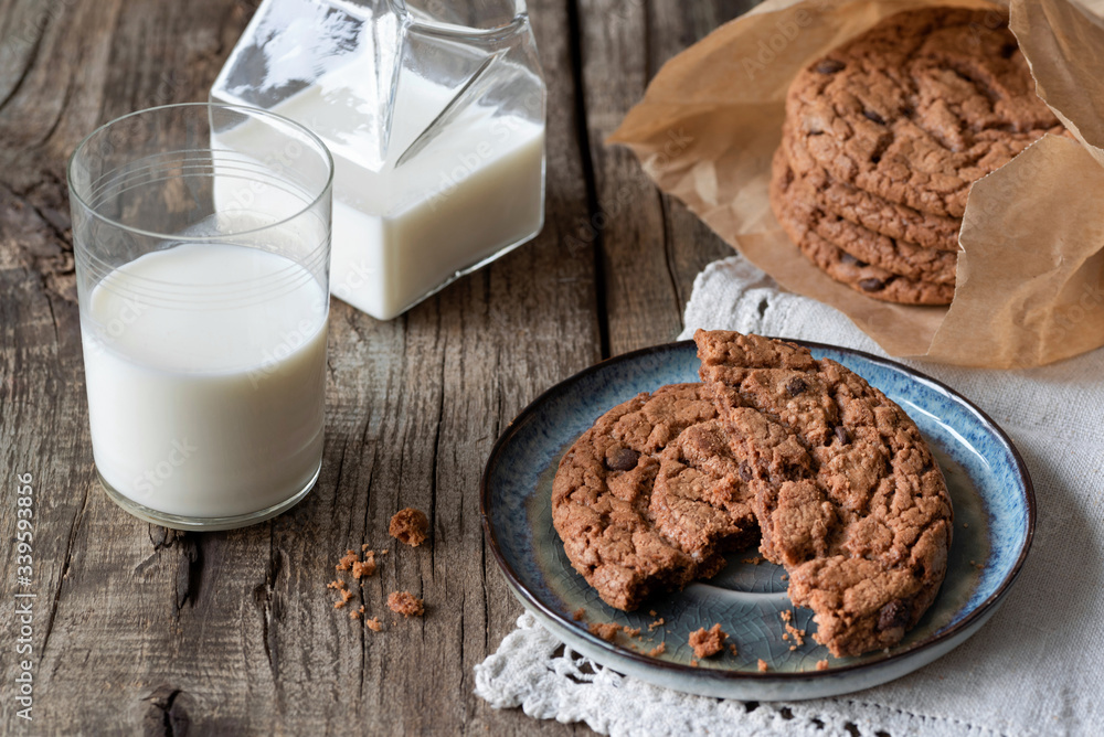 Fototapeta premium Milk and chocolate american cookies on a wooden table.