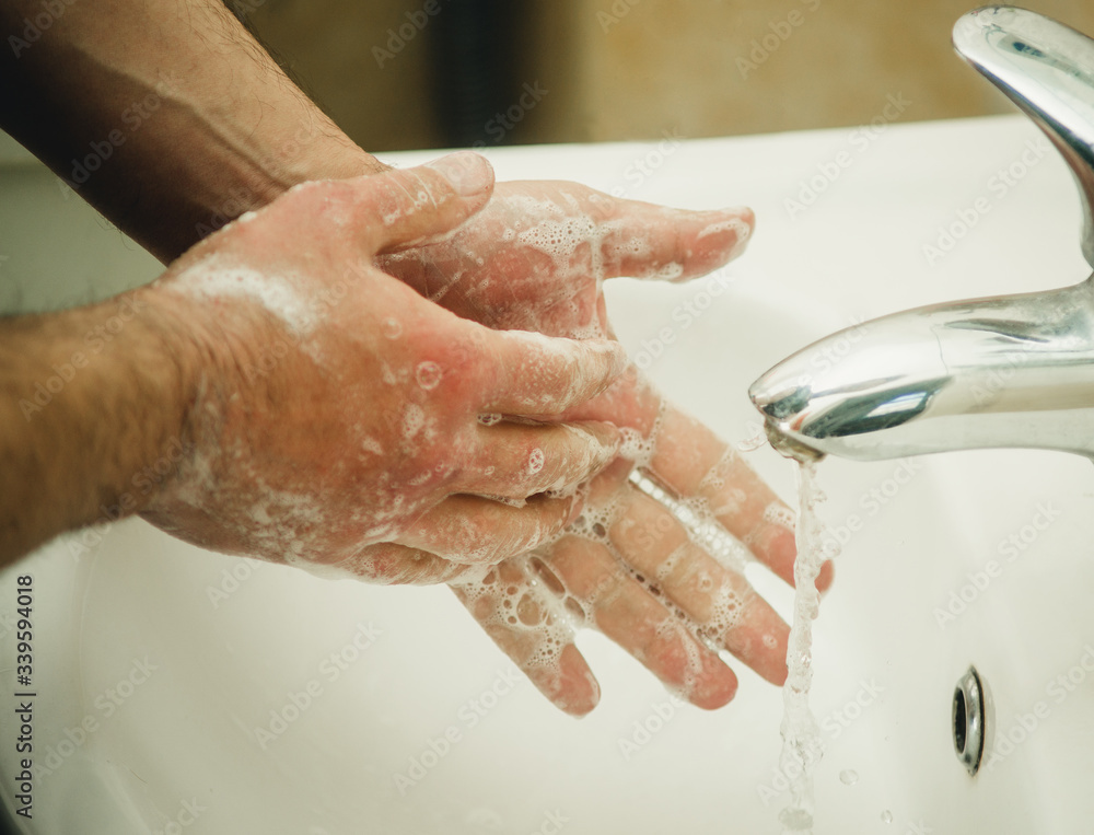 male hands in soap under the tap with water male hands in soap under the tap with water