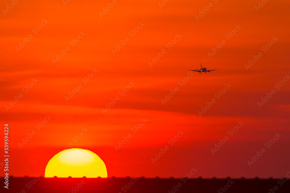 sunset over the city and plane silhouette 