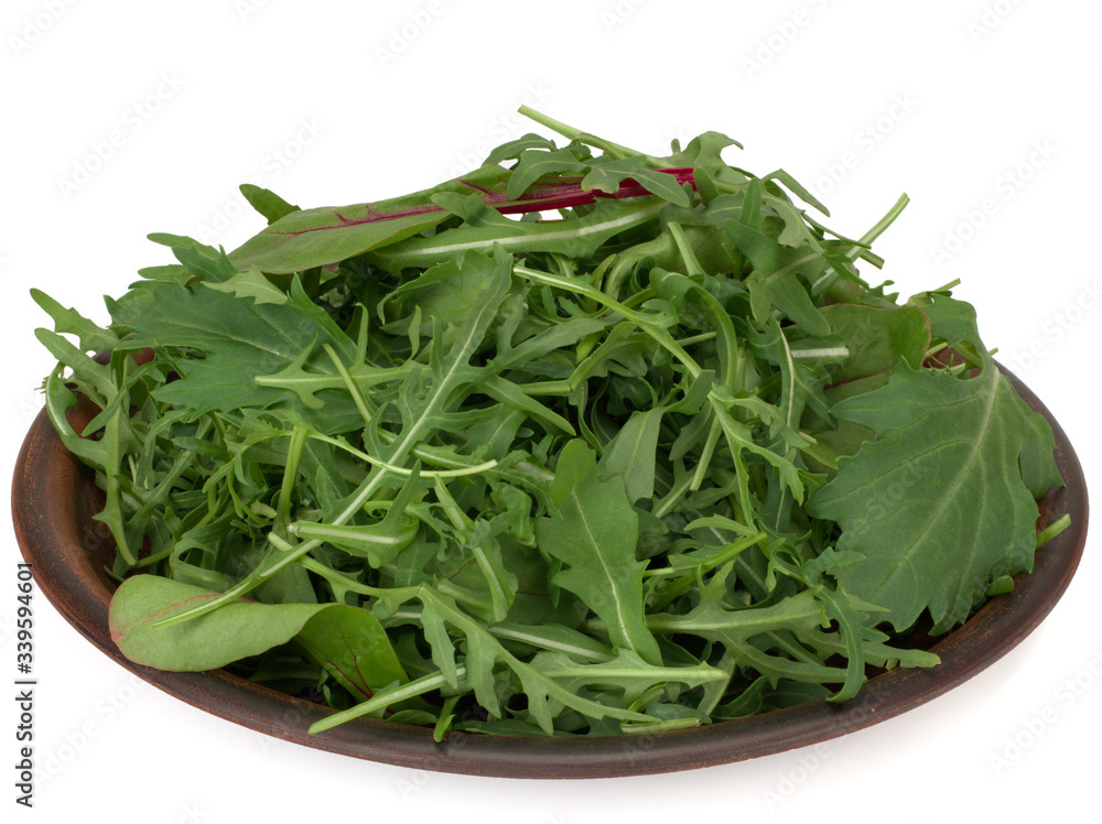 Mix of fresh lettuce, chard, arugula, mizuna, top view on a plate isolated on a white background Mix of fresh lettuce, chard, arugula, mizuna, top view on a plate isolated on a white background