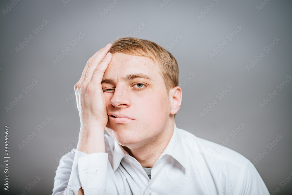 young man with tired, indifferent expression young man with tired, indifferent expression