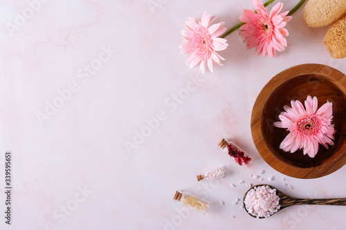 Spa product with Gerbera flowers on marble background.