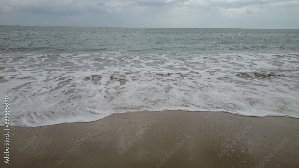 sea ??horizon, waves with foam run onto yellow sand