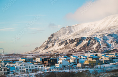 snow covered town in iceland with mountain in background