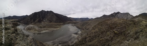 Meandering river flowing between high mountains
