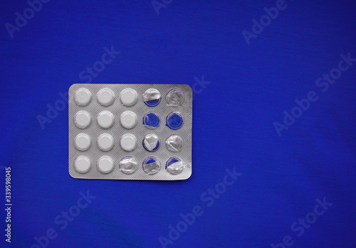 Top view on white pills on a blue background. Virus, medicine